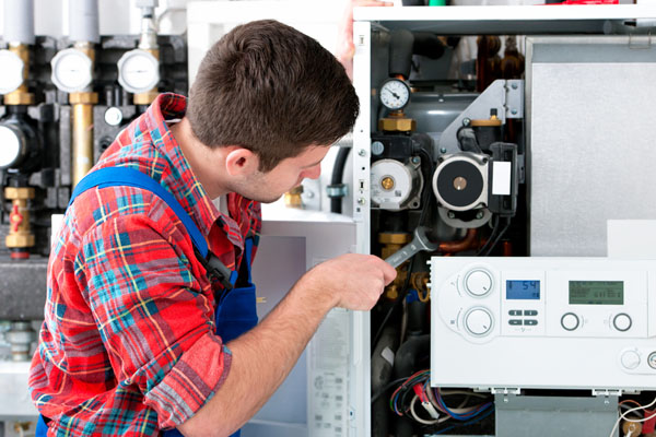 Heating technician repairing boiler controls in Lomita