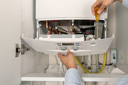Heating technician repairing a residential boiler in Lomita