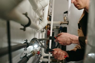 Technician inspecting commercial plumbing pipes in Lomita