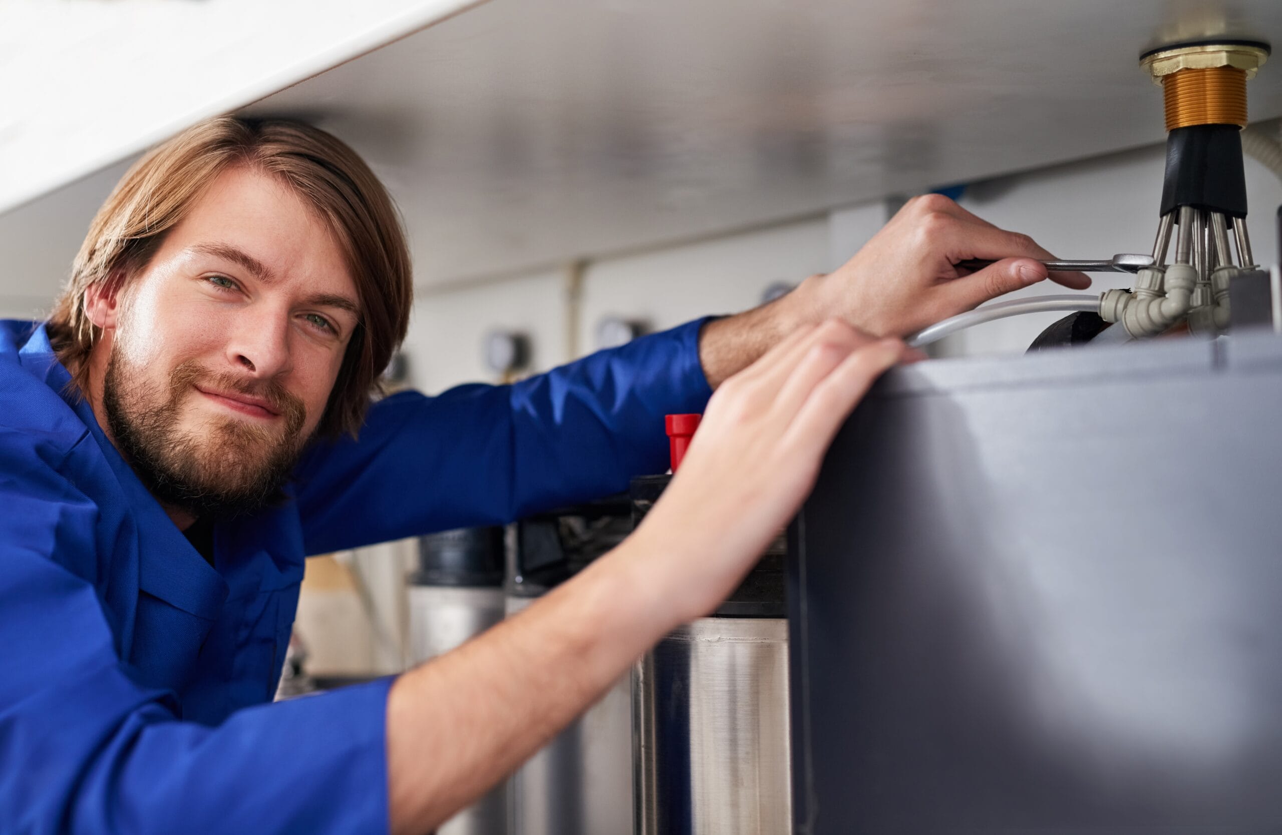 Technician servicing a residential water heater tank in Lomita